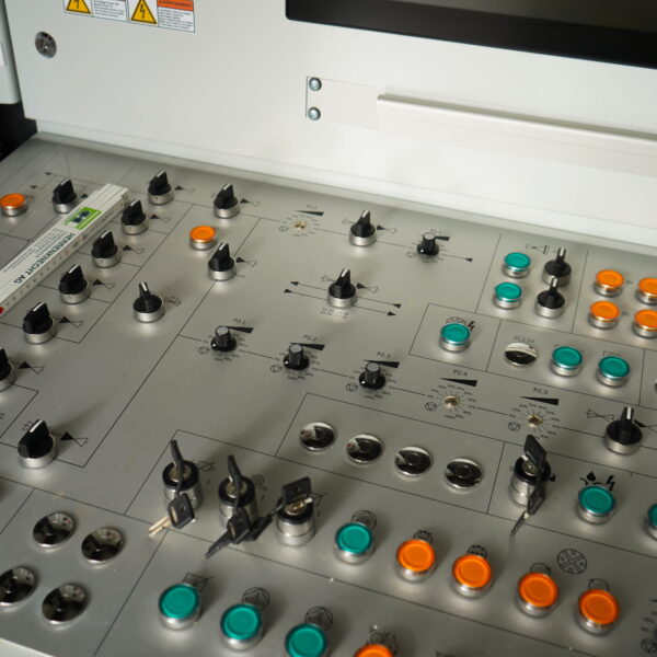 WHCRWA-Contract-64-Img3 - Big River Trenchless & GeoServices Close-up of a machine control panel with numerous orange and teal push buttons and black toggle switches.